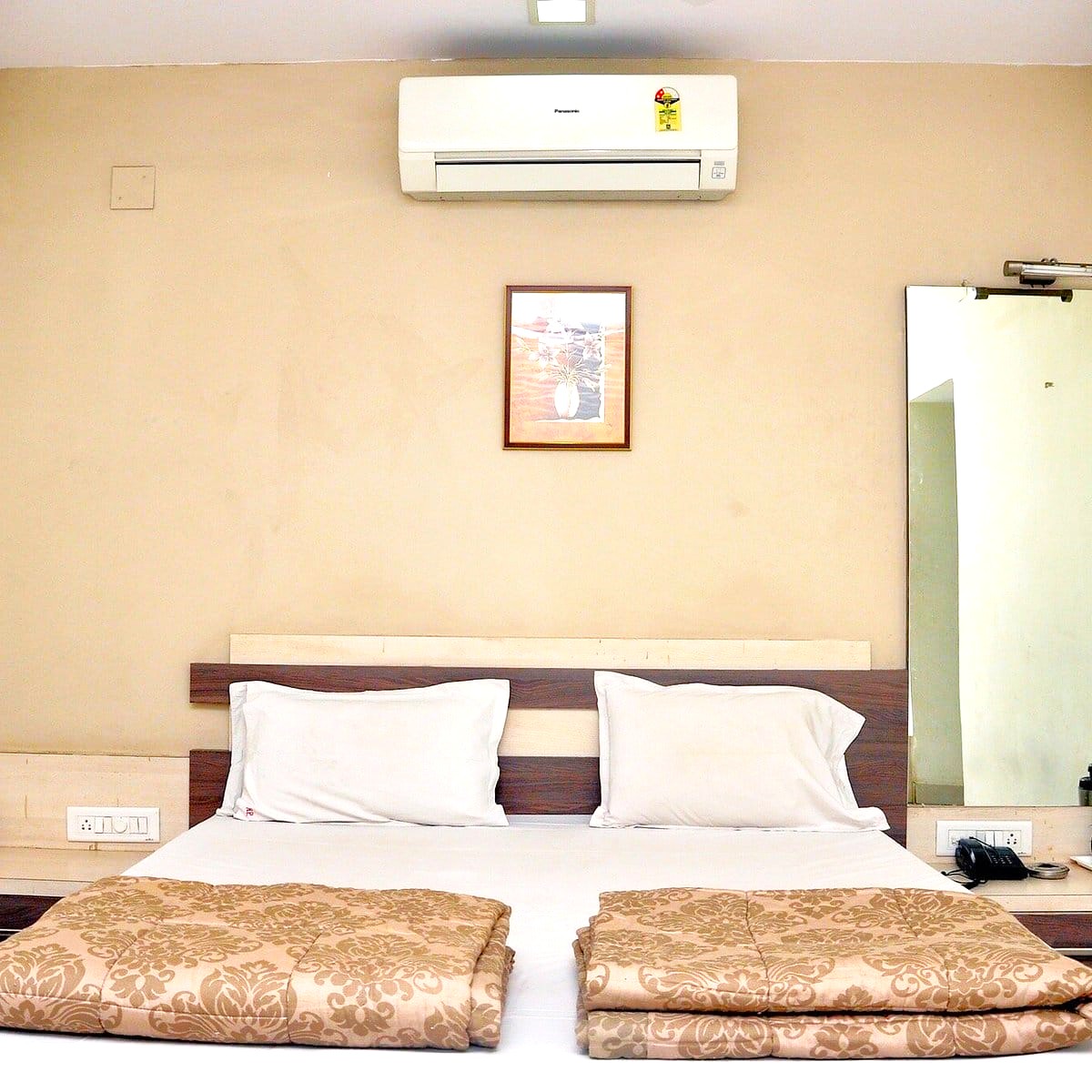 Hotel double bed AC room interior at Shree Paras White Hotel